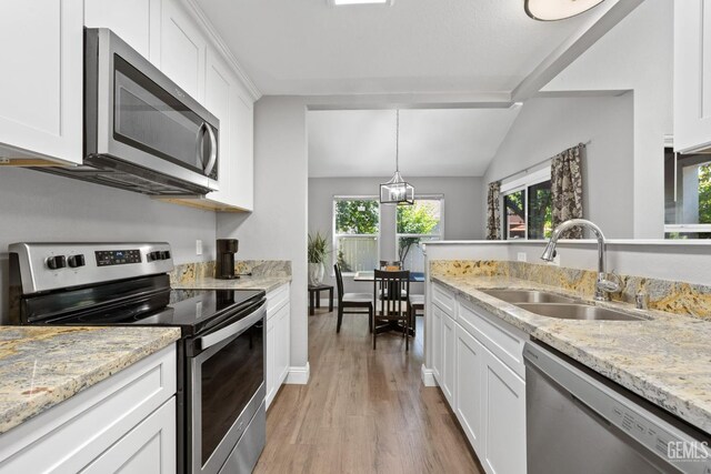 8000 Kroll Way Unit 29, Bakersfield, CA 93311 - kitchen featuring stainless steel appliances, a sink, light wood-type flooring, white cabinetry, and vaulted ceiling