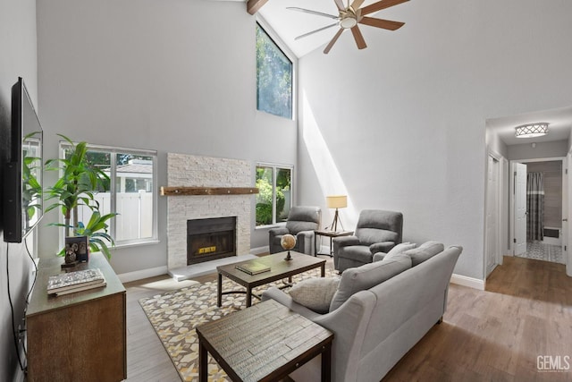 8000 Kroll Way Unit 29, Bakersfield, CA 93311 - living room featuring high vaulted ceiling, ceiling fan, a stone fireplace, wood finished floors, and baseboards