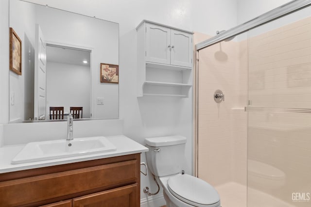 bathroom featuring vanity, toilet, and a stall shower