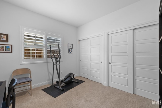 workout room featuring carpet floors and baseboards