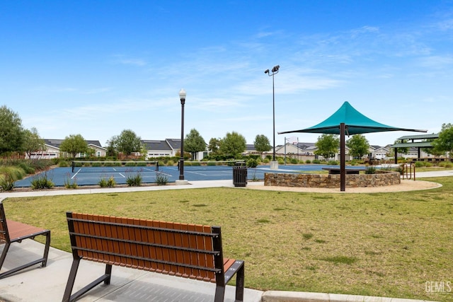 view of home's community with a yard and a tennis court