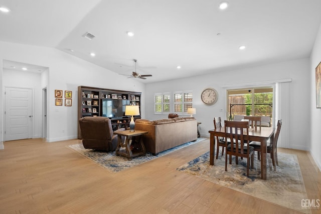 dining space with visible vents, plenty of natural light, light wood-type flooring, a ceiling fan, and vaulted ceiling