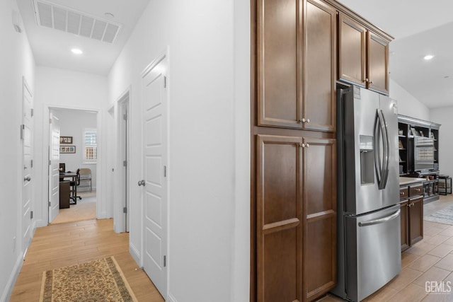 kitchen with visible vents, light countertops, light wood finished floors, stainless steel fridge, and recessed lighting