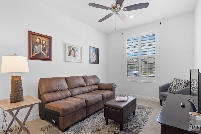 living area featuring baseboards, carpet, and a ceiling fan