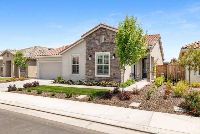 view of front of house with fence, a tile roof, a garage, stucco siding, and concrete driveway