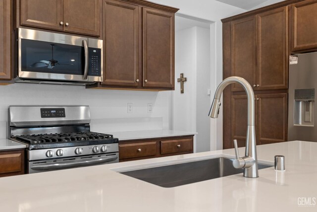 3308 Whispering Brook Ln, Shafter, CA 93263 - kitchen featuring light countertops, a ceiling fan, appliances with stainless steel finishes, and a sink