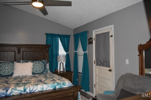 bedroom featuring vaulted ceiling, a textured ceiling, and ceiling fan