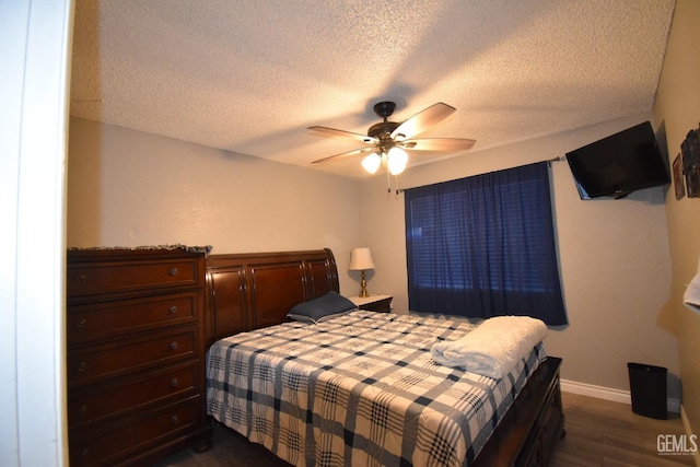 bedroom with a ceiling fan, a textured ceiling, baseboards, and dark wood-style flooring