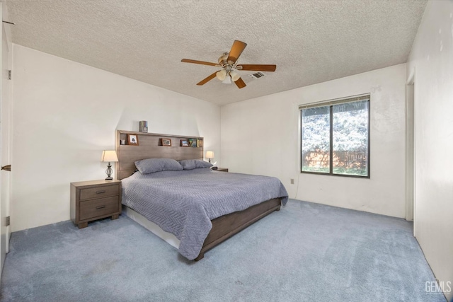 bedroom with a textured ceiling, carpet floors, visible vents, and a ceiling fan