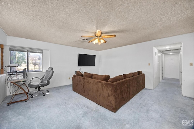 carpeted living room with ceiling fan, a textured ceiling, and visible vents