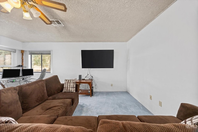 living area featuring a ceiling fan, a textured ceiling, visible vents, and carpet flooring