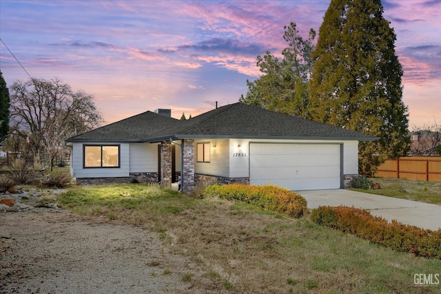 ranch-style house featuring roof with shingles, a chimney, concrete driveway, an attached garage, and fence