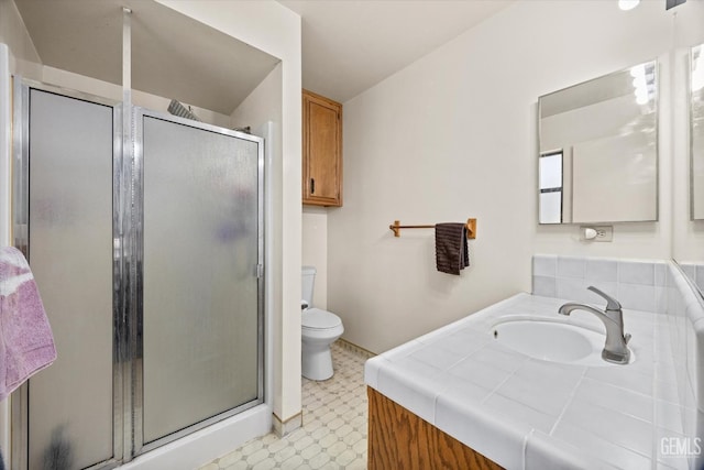 bathroom featuring toilet, a stall shower, vanity, and tile patterned floors