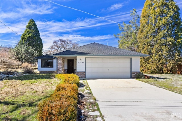 view of front facade featuring a garage, concrete driveway, and a shingled roof