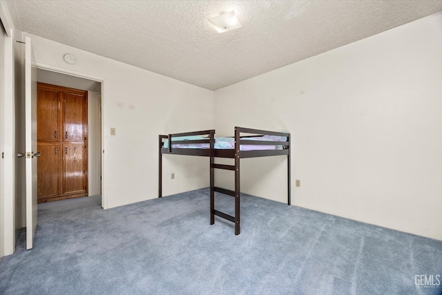 carpeted bedroom with a textured ceiling