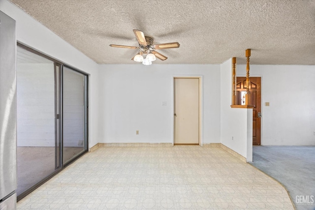 spare room featuring light floors, a textured ceiling, and a ceiling fan