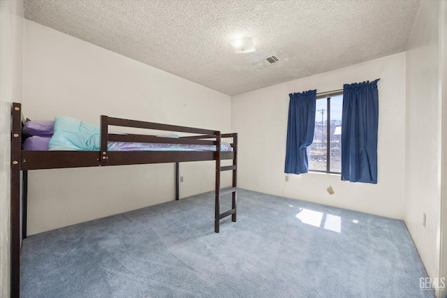 carpeted bedroom with visible vents and a textured ceiling