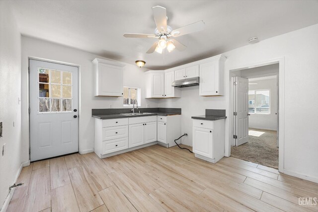 914 P St, Bakersfield, CA 93304 - kitchen with under cabinet range hood, ceiling fan, dark countertops, and light wood-style flooring