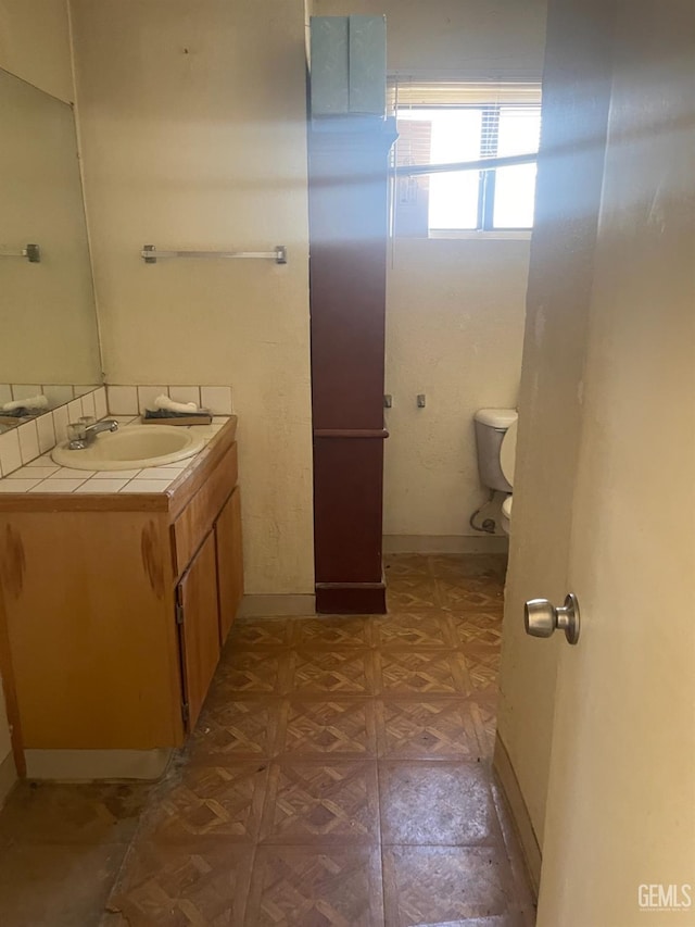 bathroom featuring vanity, toilet, and parquet floors