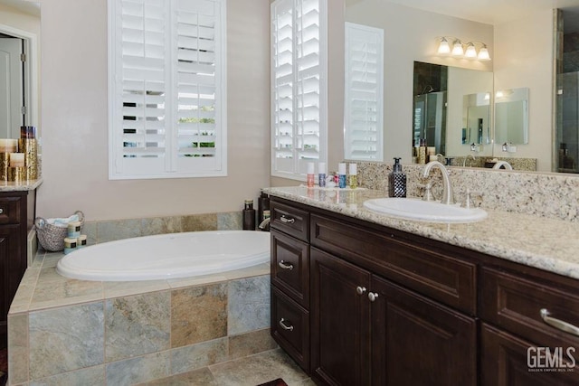 full bath featuring a bath, vanity, and a stall shower