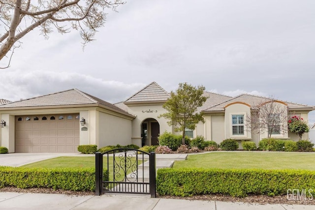 mediterranean / spanish home with a garage, a front yard, a tiled roof, and stucco siding