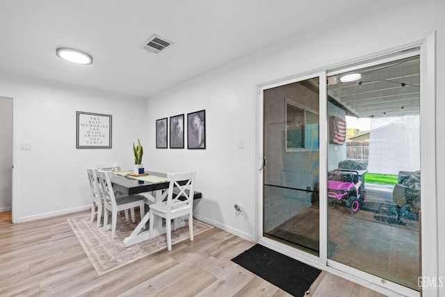 dining area featuring wood finished floors, visible vents, and baseboards