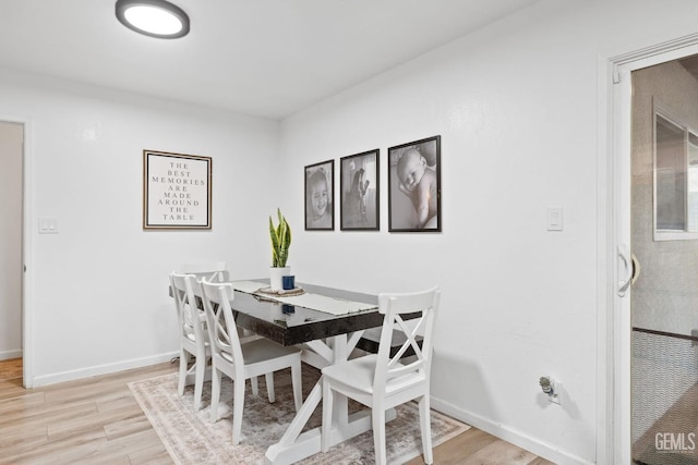 dining area featuring light wood-type flooring and baseboards