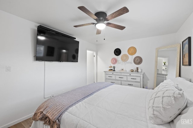 bedroom with wood finished floors, a ceiling fan, and baseboards