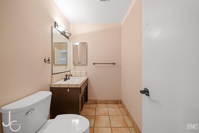 half bath featuring tile patterned flooring, baseboards, vanity, and toilet