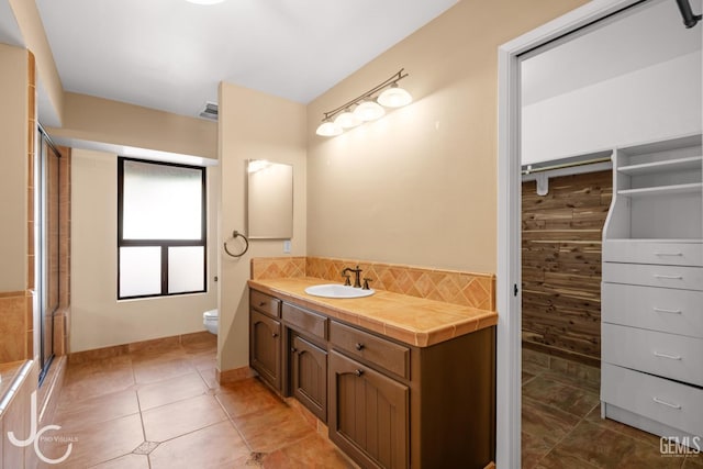 full bathroom with tile patterned flooring, toilet, visible vents, vanity, and backsplash