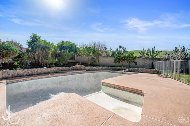 view of swimming pool with a patio and fence