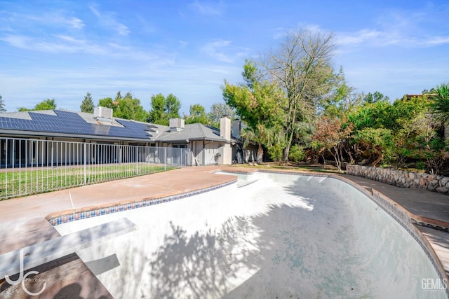 view of swimming pool featuring fence