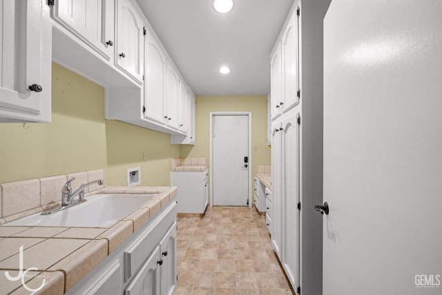 clothes washing area featuring washer hookup, cabinet space, a sink, and recessed lighting