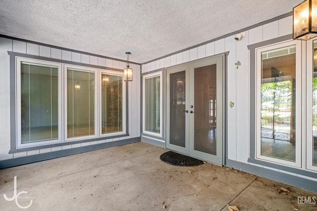 entrance to property featuring board and batten siding and a patio area