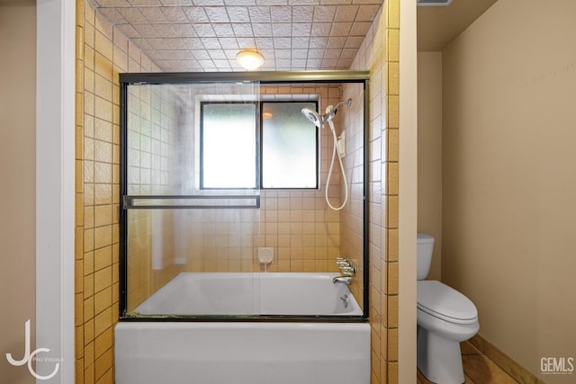 full bathroom with shower / bath combination with glass door and toilet