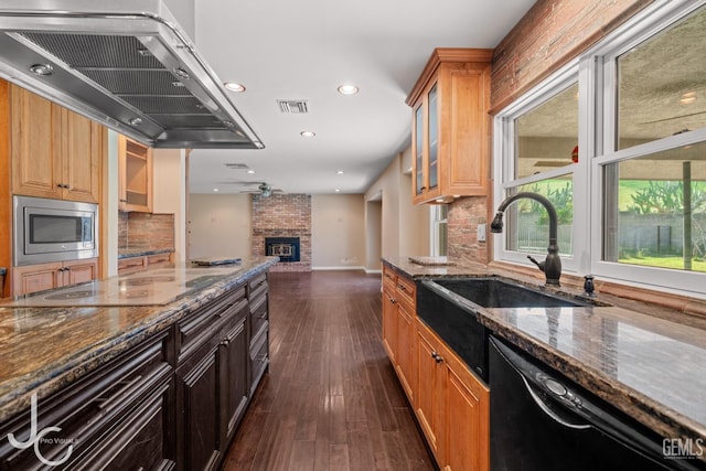 kitchen with extractor fan, visible vents, black appliances, dark stone countertops, and glass insert cabinets