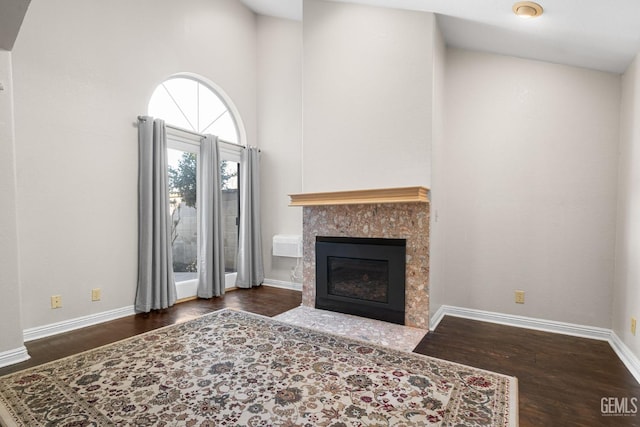 living room featuring a tiled fireplace and dark hardwood / wood-style floors