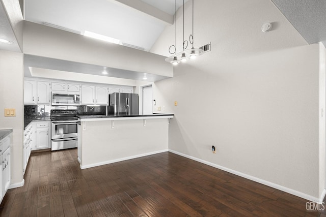 kitchen featuring a breakfast bar, white cabinetry, appliances with stainless steel finishes, kitchen peninsula, and pendant lighting