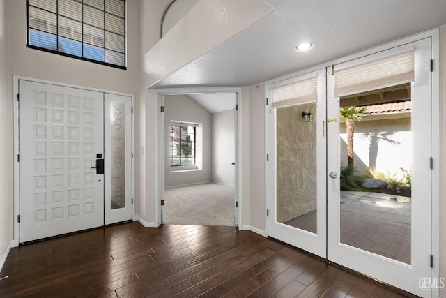 foyer with lofted ceiling, dark hardwood / wood-style flooring, and french doors