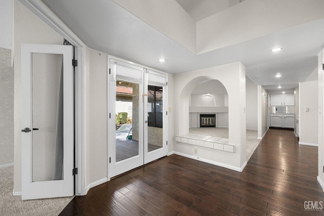 unfurnished living room with a tile fireplace and dark hardwood / wood-style floors