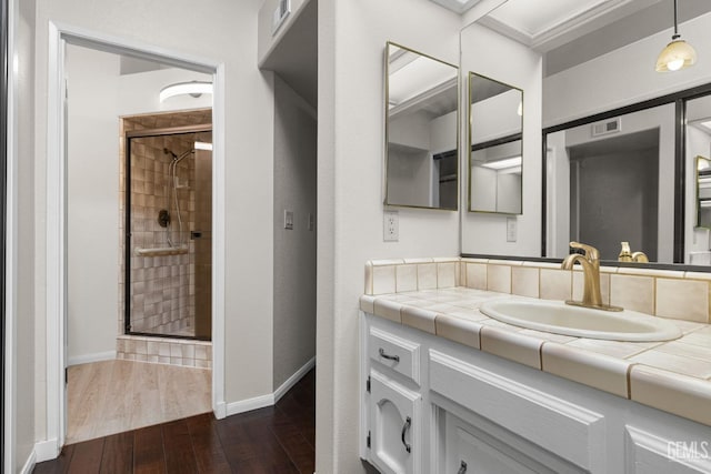 bathroom with hardwood / wood-style flooring, vanity, and an enclosed shower