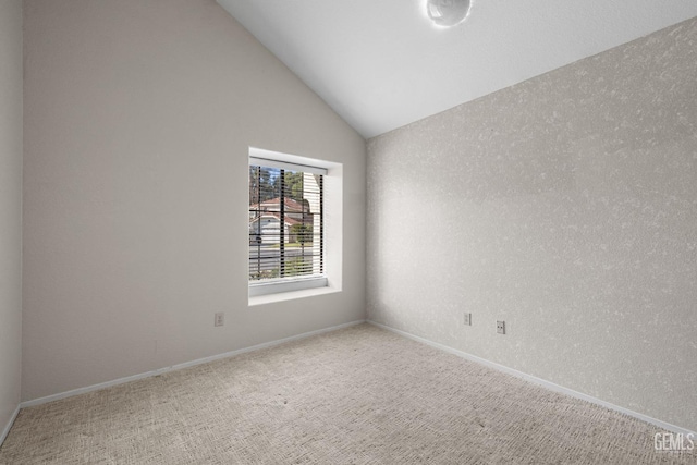 empty room featuring carpet floors and vaulted ceiling