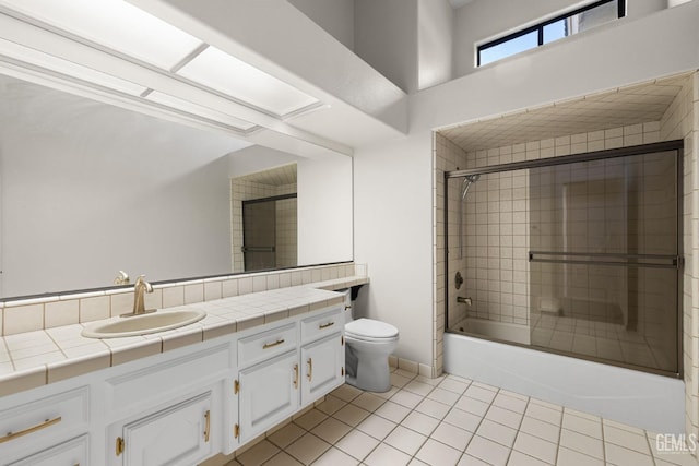 full bathroom featuring vanity, tile patterned flooring, enclosed tub / shower combo, and toilet