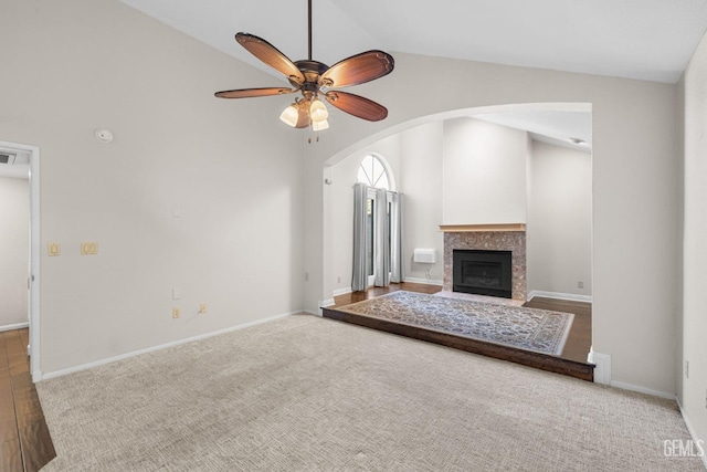 unfurnished living room featuring high vaulted ceiling and ceiling fan