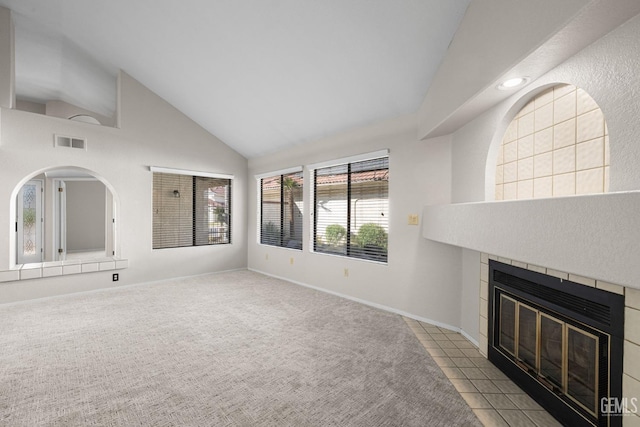 unfurnished living room with light tile patterned floors, a fireplace, and high vaulted ceiling