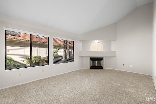 unfurnished living room with lofted ceiling, carpet floors, and a tile fireplace