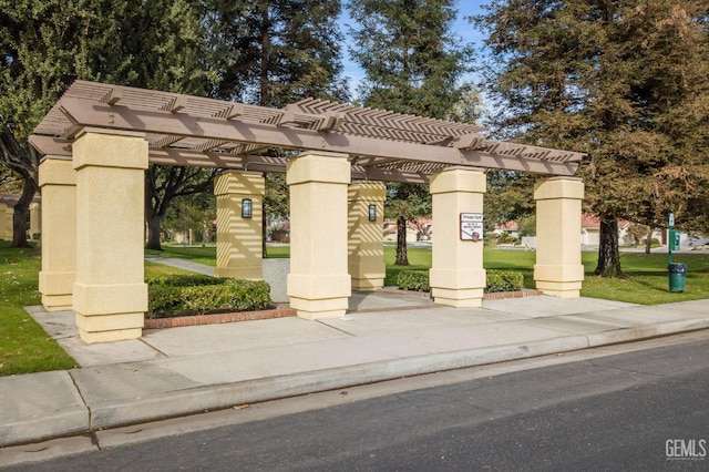 view of property's community featuring a yard and a pergola