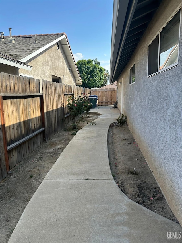 view of side of property with stucco siding, a fenced backyard, and a patio area