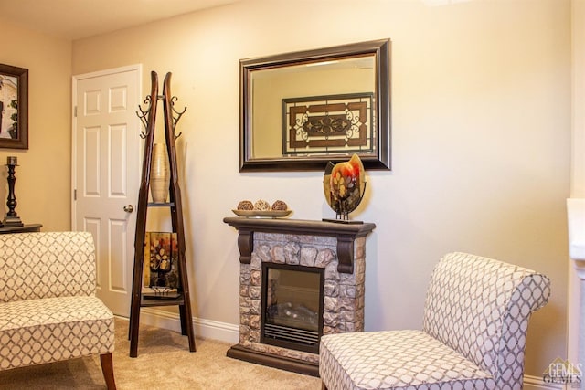 sitting room featuring a fireplace and light colored carpet