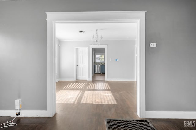 hall featuring a chandelier, hardwood / wood-style floors, and ornamental molding